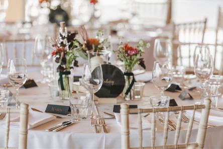 Autumn British flowers bud vases mini milk bottles on wedding table display with books and candles Chalk Barn Dan Watkins My Flower Patch 